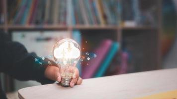 nube calcolo concetto, bambini idea e nube tecnologia, ragazza mano Tenere leggero lampadina e icona mostrare concetto di ragazzo e nuovo tecnologia foto