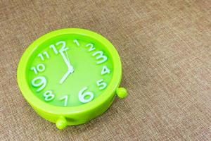 verde allarme orologio su Marrone tela di sacco sfondo mostrare otto alle o 8.00 am foto