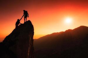 squadra di alpinisti aiuta a conquistare la vetta foto