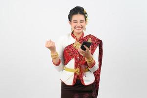 giovane bellissimo donna vestito su nel tailandese settentrionale regione posa con smartphone foto