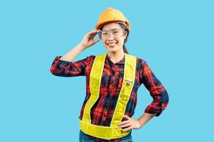 giovane femmina ingegnere nel casco In piedi toccare su sicurezza occhiali posizione foto