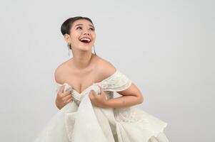 giovane asiatico bellissimo sposa posa con eccitato sentire su bianca sfondo foto