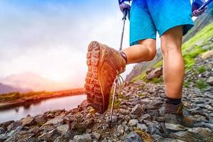 primo piano di scarpone da trekking sul sentiero di montagna foto