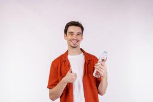 ritratto di contento giovane uomo mostrando acqua nel un' bottiglia isolato al di sopra di bianca sfondo foto