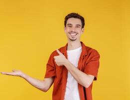 ritratto di contento sorridente giovane uomo presentazione e mostrando il tuo testo o Prodotto isolato su giallo sfondo foto