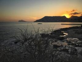 spiaggia mediterranea senza persone al tramonto a calpe, alicante foto