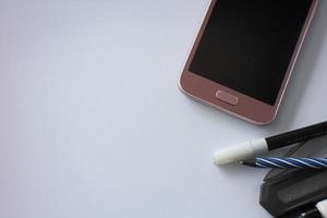 smartphone con penna su bianca sfondo, attività commerciale idea, superficiale messa a fuoco foto