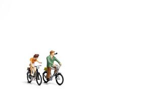coppia in miniatura in sella a biciclette su uno sfondo bianco, il concetto di San Valentino foto