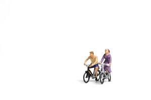 coppia in miniatura in sella a biciclette su uno sfondo bianco, il concetto di San Valentino foto