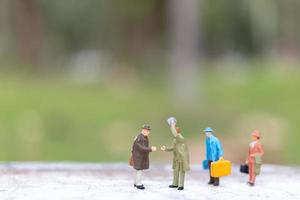 viaggiatori in miniatura che camminano su una strada, viaggi e concetto di avventura foto