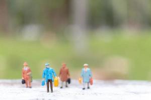 viaggiatori in miniatura che camminano su una strada, viaggi e concetto di avventura foto