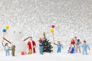 Babbo Natale in miniatura e bambini con uno sfondo di neve, Natale e felice anno nuovo concetto foto