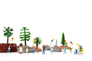 famiglia in miniatura che tiene palloncini nel parco, concetto di giornata mondiale dei bambini
