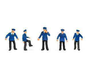 poliziotti in miniatura in piedi isolato su uno sfondo bianco foto