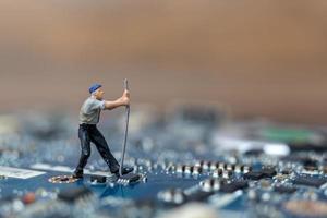 persona in miniatura che lavora su una scheda CPU, concetto di tecnologia foto