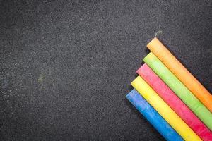 fila di gesso colorato arcobaleno su una lavagna foto