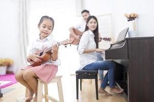 genitori e figlia che suonano strumenti musicali foto