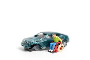 persona in miniatura sulla scena di un incidente stradale, incidente stradale su uno sfondo bianco, concetto di guida in sicurezza foto