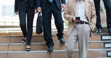le gambe dell'uomo d'affari che camminano le scale nella città moderna foto