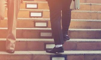 le gambe dell'uomo d'affari che camminano le scale nella città moderna foto