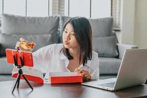 blogger di cibo donna che mangia pizza durante la creazione di nuovi contenuti video foto