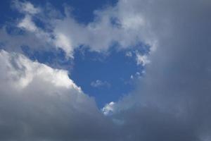 bianca nuvole formatura un' cuore a il blu cielo foto