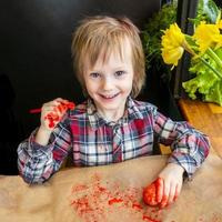 il bambino preparazione per Pasqua. dipingere uova. rosso dipingere uovo. foto