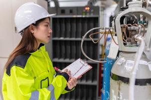 asiatico ingegnere Lavorando a operativo sala, Tailandia persone indossare casco lavoro, lui lavorato con diligenza e pazienza, lei verificato il valvola regolatore a il idrogeno cisterna. foto