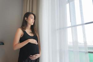 ritratto di asiatico incinta donna nel il Camera da letto foto