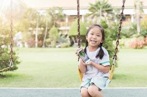 carino ragazza mostrare inteligente Telefono nel bambini terreno di gioco foto