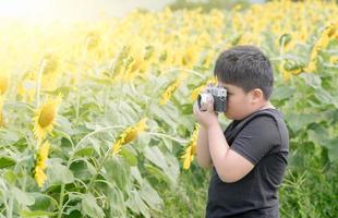 bambino Tenere vecchio telecamera per prendere fotografie girasole fiore