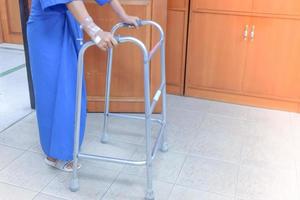 femmina pazienti pratica a piedi con un' camminatore nel il ospedale . foto
