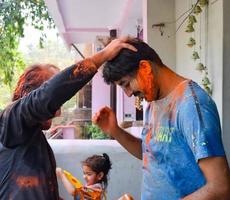 delhi, India - febbraio 26 2023 - indiano famiglia persone giocando colori su holi Festival, Tenere diverso colori, holi Festival celebrazioni nel delhi, India foto