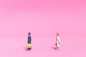 coppia in miniatura di viaggiatori su uno sfondo rosa foto