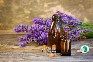 lavanda olio nel diverso bottiglie su di legno sfondo. foto