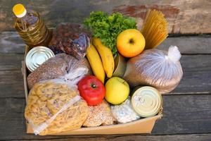 donazione scatola con cibo su vecchio di legno sfondo foto