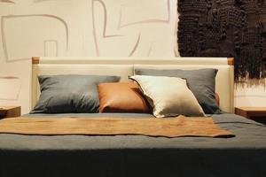 avvicinamento di confortevole colorato morbido cuscini su letto. elegante di moda appartamento casa arredamento. hygge scandinavo soffitta design. interno di moderno Camera da letto nel Hotel. comfort dormire e rilassare concetto. foto