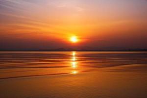 drammatico tramonto al di sopra di montagna e mare. foto