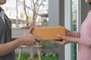 contento sorridente donna riceve scatole pacco a partire dal Corriere nel davanti Casa. consegna uomo Spedire consegnare esprimere. in linea acquisti, carta contenitori, porta via, postino, consegna servizio, pacchi foto