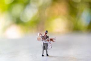 sposa e sposo in miniatura all'aperto con uno sfondo verde bokeh foto