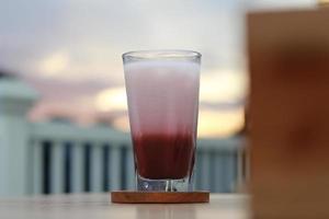 un' bicchiere di rosso velluto latte macchiato servito freddo su il tavolo. foto