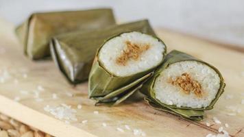 un' vicino su di lungo. tradizionale cibo a partire dal Indonesia originario a partire dal riso pieno con verdure o carne e avvolto nel Banana le foglie. indonesiano tradizionale cibo foto concetto.