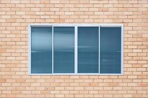 moderno bicchiere finestra su il mattone parete, coperta finestra telaio foto