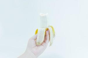 il pelato Banana nel un' femmina mano Tenere su bianca sfondo, banana frutta foto