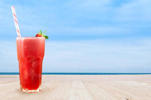 fragola succo frullato nel bicchiere con fresco fragola su tavolo di legno con spiaggia paesaggio Visualizza natura sfondo foto