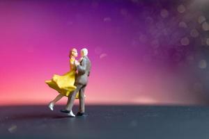 coppia in miniatura che balla con uno sfondo colorato bokeh foto