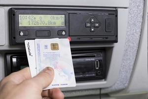 olomouc, repubblica ceca 2021 - mano che tiene una carta digitale del conducente, una carta di debito bancario e un tachigrafo digitale stampati davanti a un tachigrafo digitale