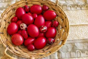 molti Pasqua rosso colorato uova nel il cestino su il tavolo. superiore Visualizza foto