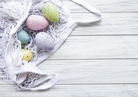 sacchetto di stringa con uova di Pasqua e fiori primaverili foto