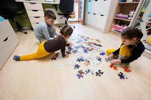 bambini collegamento sega puzzle pezzi nel un' bambini camera su pavimento a casa. divertimento famiglia attività tempo libero. foto